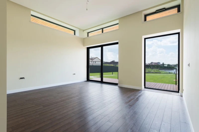 Empty room with tall glass doors opening onto a terrace