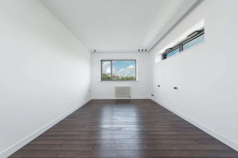 Empty rental flat with white walls and a high window
