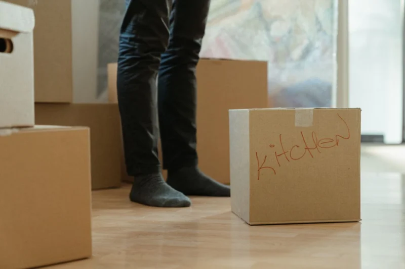 Tenant standing among moving boxes in a rented home