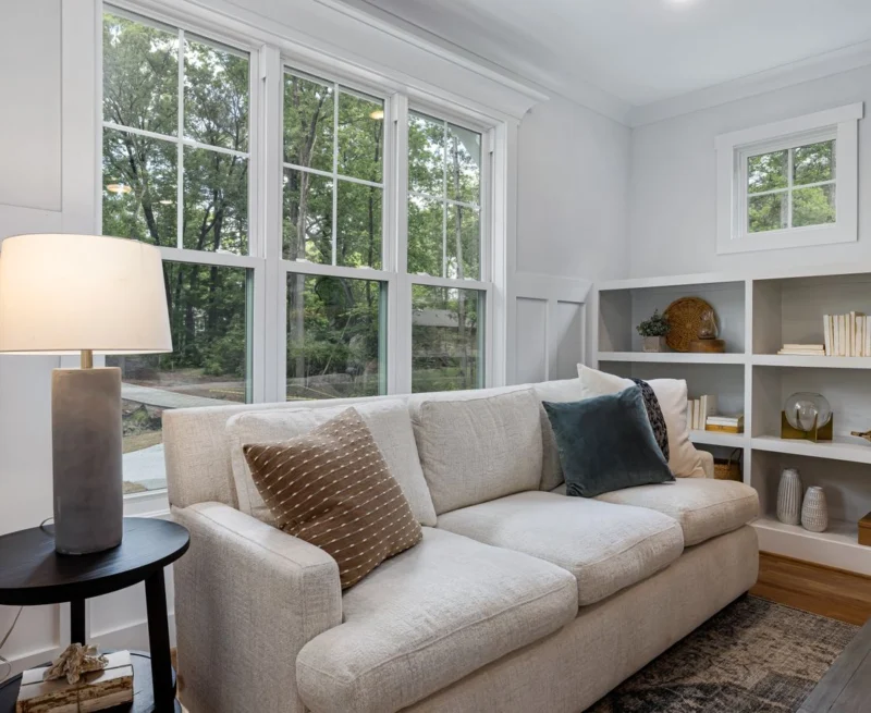 Living room with tall white-framed windows and a sofa
