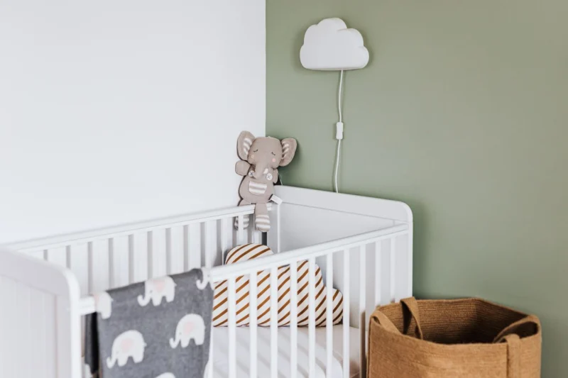 Nursery with a white cot and toy storage