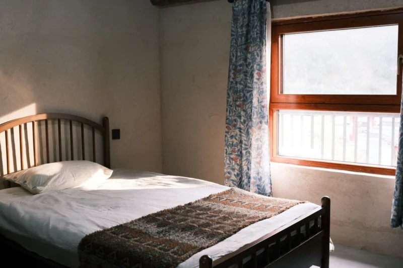 Bedroom with daylight through a window beside the bed