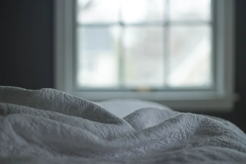 Bed by a window in soft morning light
