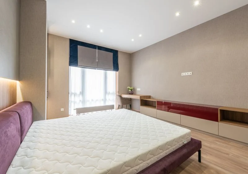 Bedroom with a navy roller blind lowered over the window