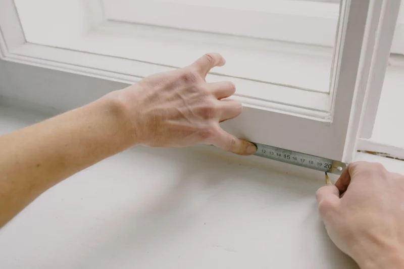 Measuring a window frame with a metal rule