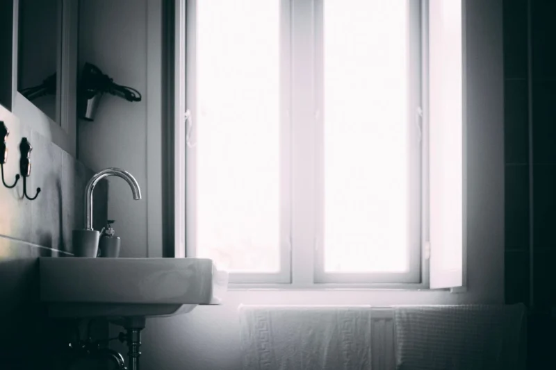 Bathroom sink beside a bright window