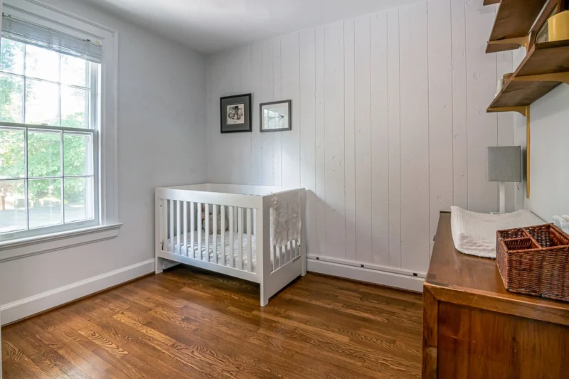 Nursery blinds for a nursery with a white cot beside a window