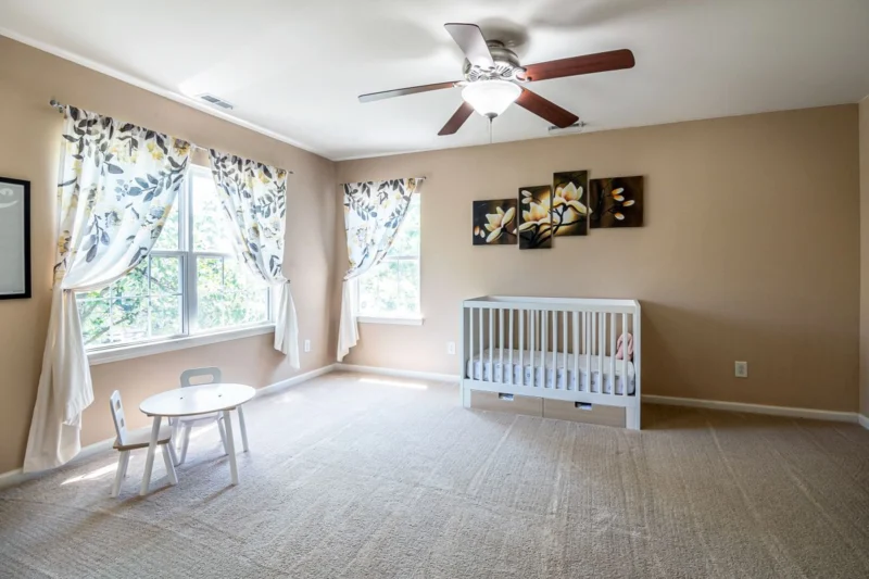 Nursery with a cot, small table and floral curtains