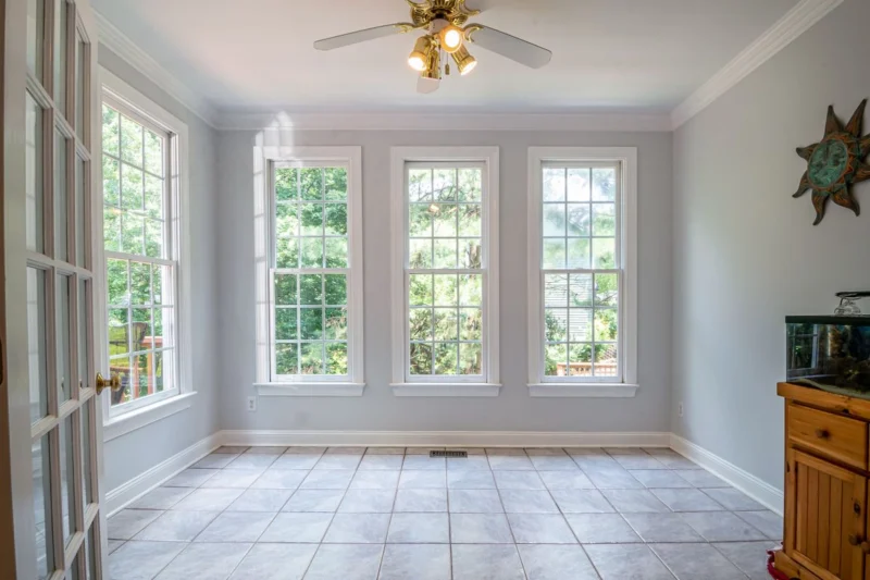 Perfect fit vs roller blinds: a sunroom with white-framed windows on three sides