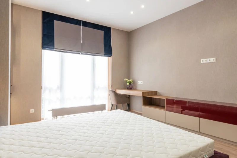 Bedroom window with a fabric blind partly lowered