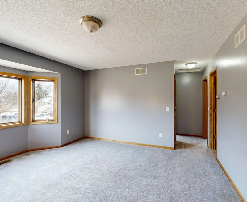 Empty room with a wide bay window and wooden floor