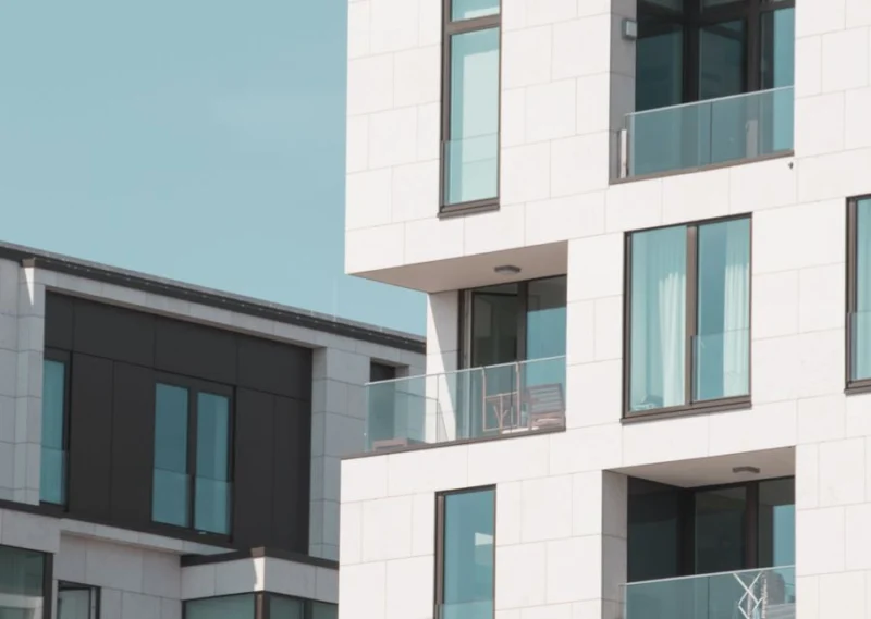 Modern white apartment block with full-height windows and balconies
