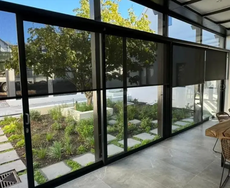 Sunscreen blind lowered — garden clearly visible through the fabric